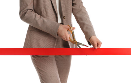 Woman in office suit cutting red ribbon isolated on white, closeupの写真素材