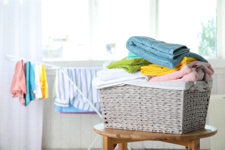 Basket with clean laundry on table at home, space for textの写真素材