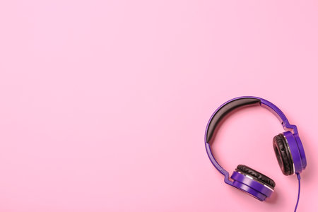 Stylish modern headphones on color background, top view. Space for textの写真素材
