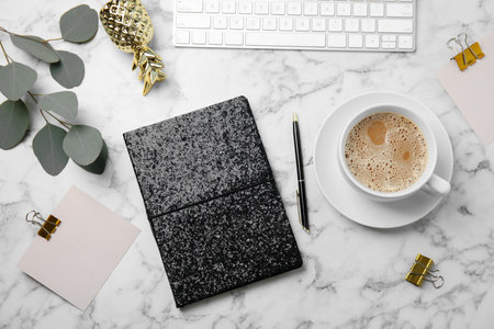Blogger's workplace with notebook, keyboard and coffee on marble table, flat layの写真素材