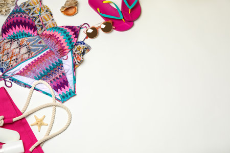 Flat lay composition with swimsuit and beach accessories on white background. Space for textの写真素材