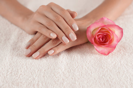 Woman with smooth hands and flower on towel, closeup. spa treatmentの写真素材