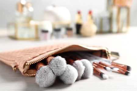 Cosmetic bag with makeup brushes on tableの写真素材