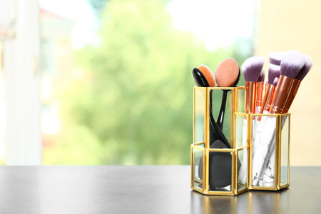 Organizer with makeup brushes on table. Space for textの写真素材