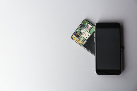 Composition with mobile phones on gray background, top view with space for text. Repair service