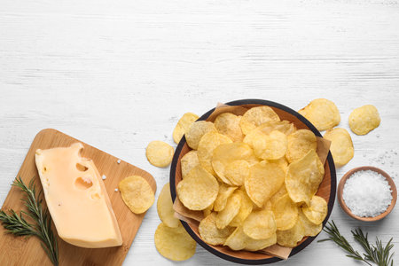 Flat lay composition with delicious crispy potato chips on table, space for textの写真素材