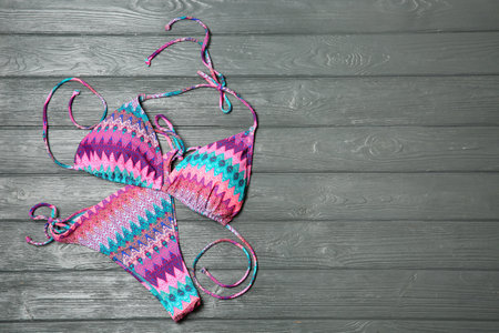 Stylish bikini on wooden background, flat lay. Space for textの写真素材