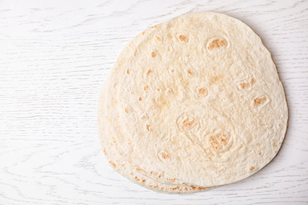 Corn tortillas and space for text on white wooden background, top view. Unleavened breadの写真素材