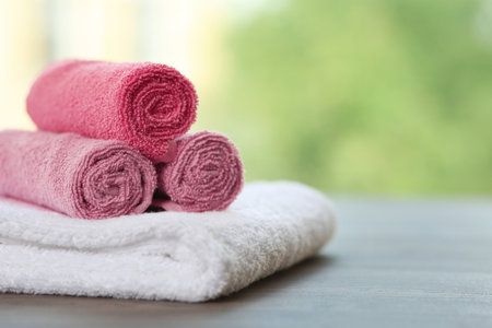 Clean towels on table against blurred background. Space for textの写真素材