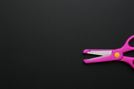 Pair of training scissors on dark background, top view. Space for textの写真素材