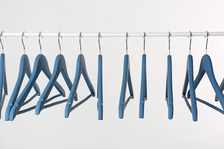 Metal rack with clothes hangers on white backgroundの写真素材