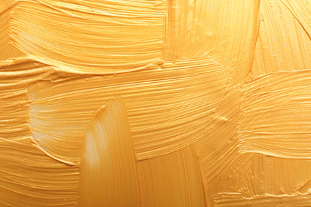 Strokes of gold paint as background, top viewの写真素材