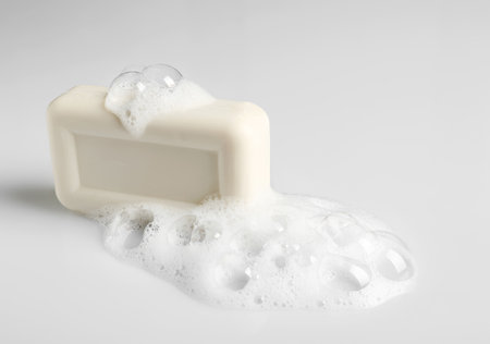 Soap bar and foam on white background