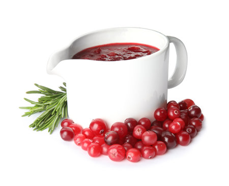 Pitcher of cranberry sauce with rosemary on white backgroundの写真素材