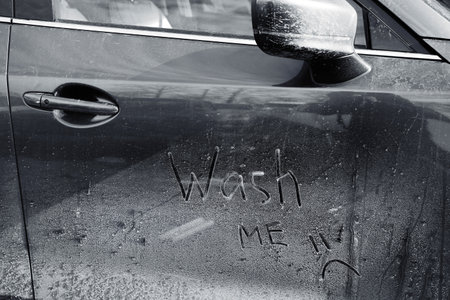 Inscription WASH ME and sad smiley on car door, closeupの写真素材