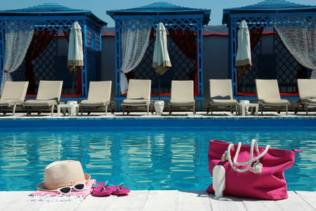 Beach accessories on wooden deck near swimming pool. Space for textの写真素材