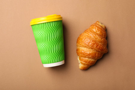 Paper coffee cup and croissant on color background, flat layの写真素材