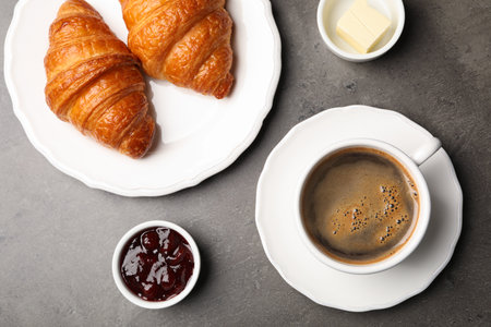 Flat lay composition with cup of coffee and croissants on gray backgroundの写真素材