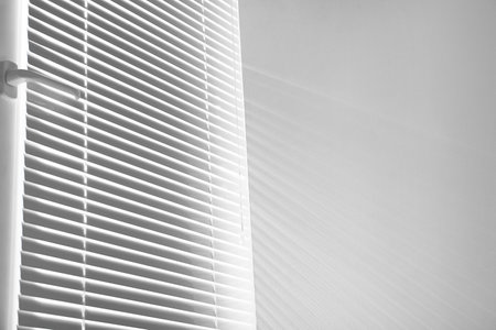 Window with closed horizontal blinds indoors. Space for textの写真素材