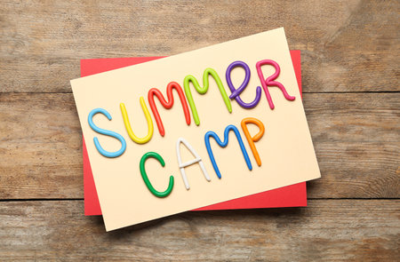 Text SUMMER CAMP made of modeling clay on wooden table, flat layの写真素材