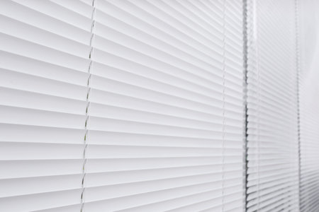 Window with closed white horizontal blinds as backgroundの写真素材