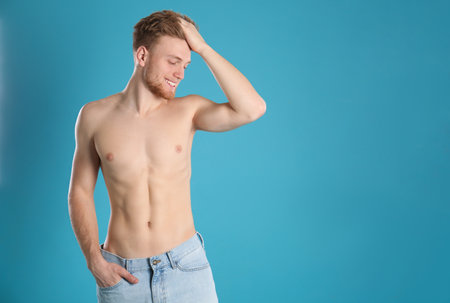 Handsome man with slim body on color background. Space for textの写真素材