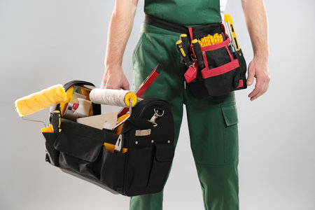 Professional construction worker with set of tools on gray background, closeupの写真素材