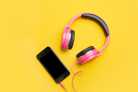 Stylish headphones and modern phone on color background, flat lay. Space for textの写真素材