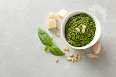 Composition with bowl of tasty pesto sauce on gray table, flat lay. Space for textの写真素材