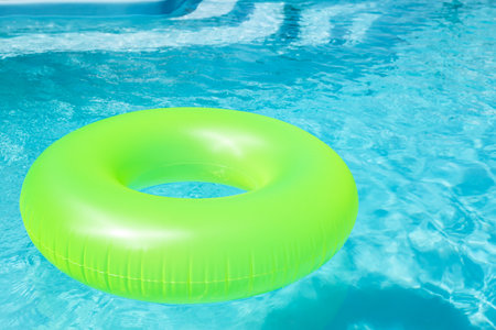 Bright inflatable ring floating in swimming pool on sunny dayの写真素材