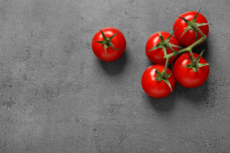 Fresh cherry tomatoes on stone background, flat lay. Space for textの写真素材
