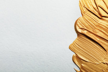 Golden paint brush strokes on white background. Space for textの写真素材