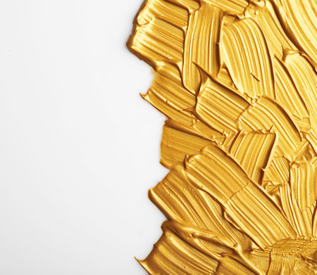 Strokes of gold paint isolated on white, top viewの写真素材
