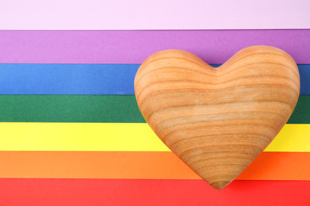 Wooden heart on rainbow background, top view. gay symbolの写真素材