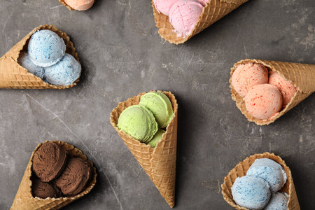 Flat lay composition with delicious ice creams in waffle cones on table