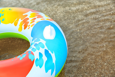 Bright inflatable ring floating on sea water. Space for text