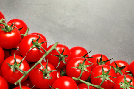 Heap of fresh cherry tomatoes on stone background, top view. Space for textの写真素材