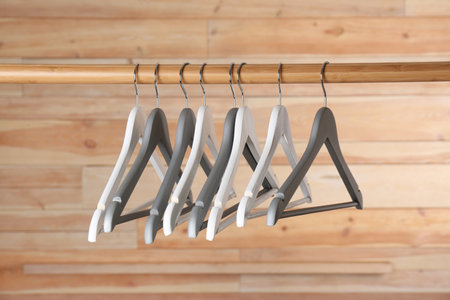 Rack with clothes hangers on wooden backgroundの写真素材