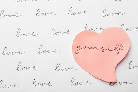 Composition with words LOVE YOURSELF and paper heart on white background, top viewの写真素材