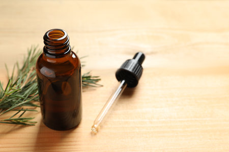 Bottle of natural tea tree oil, dropper and plant on table, space for textの写真素材