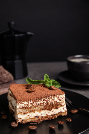 Composition with tiramisu cake on table against dark backgroundの写真素材
