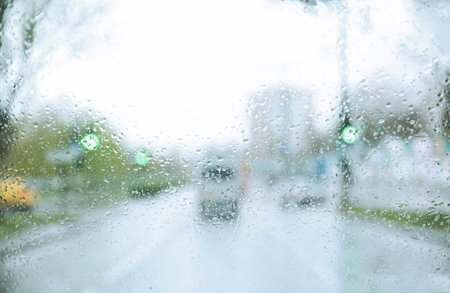 Blurred view of road through wet car window. rainy weather