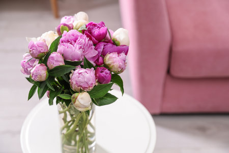 Bouquet of fresh peonies on table in room, space for textの写真素材
