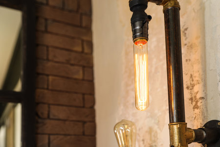 Retro lamp in steam punk style on the wall indoors. Space for textの写真素材