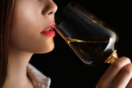 Young woman with glass of luxury white wine on black background, closeup viewの写真素材