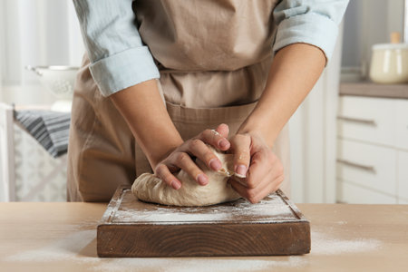 Female baker preparing bread dough at table, closeup