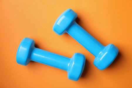 Bright dumbbells on color background, flat lay. home fitnessの写真素材