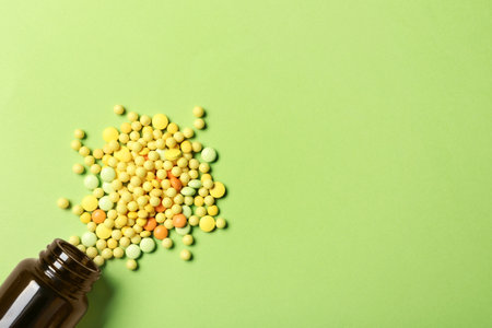 Bottle with vitamin pills on color background, flat lay. Space for textの写真素材