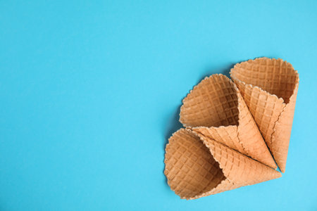 Waffle empty ice cream cones on color background, flat lay. Space for textの写真素材