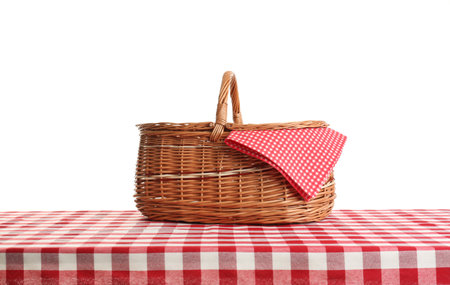 Empty picnic basket on checkered tablecloth against white backgroundの写真素材